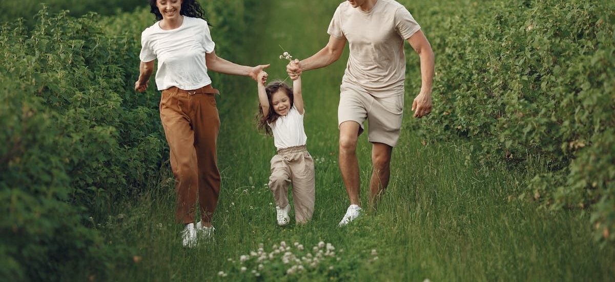 Joyful family enjoying a fun day outdoors in a green field, epitomizing togetherness and happiness.