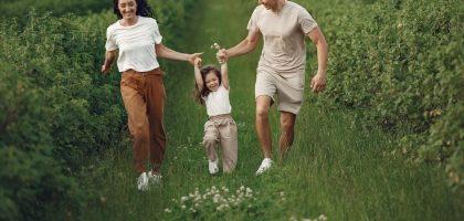 Joyful family enjoying a fun day outdoors in a green field, epitomizing togetherness and happiness.