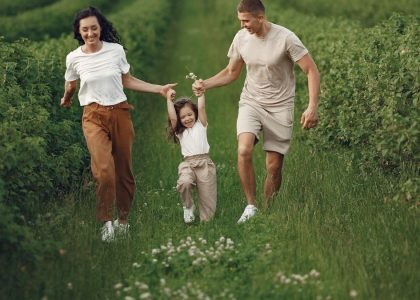 Joyful family enjoying a fun day outdoors in a green field, epitomizing togetherness and happiness.